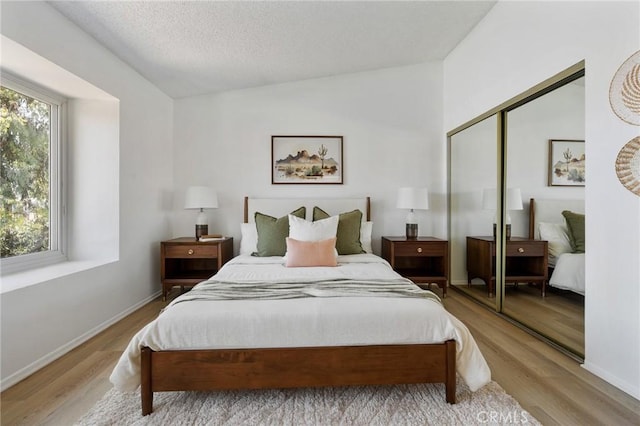 7038 De Celis Pl Unit 4, Van Nuys, CA 91406 - bedroom featuring light wood-type flooring, lofted ceiling, a closet, and a textured ceiling