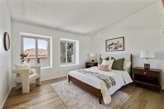 7038 De Celis Pl Unit 4, Van Nuys, CA 91406 - bedroom with a textured ceiling, light wood-style flooring, and lofted ceiling