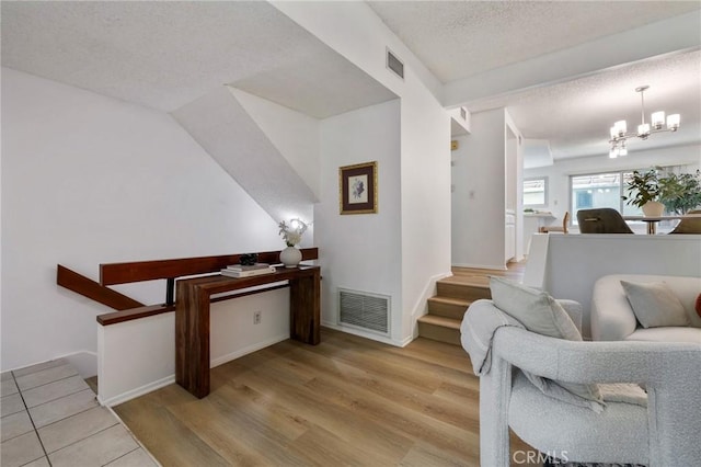 7038 De Celis Pl Unit 4, Van Nuys, CA 91406 - sitting room featuring a chandelier, a textured ceiling, wood finished floors, and stairway