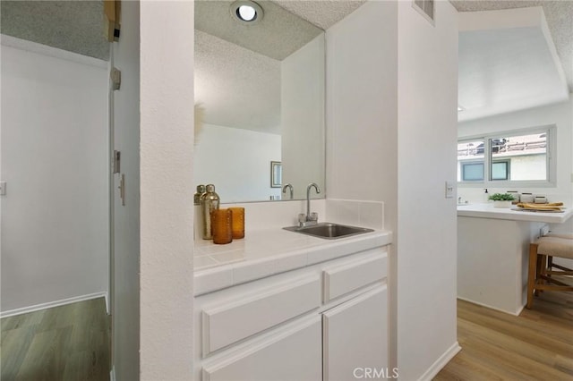 7038 De Celis Pl Unit 4, Van Nuys, CA 91406 - bathroom featuring a textured ceiling, wood finished floors, and vanity