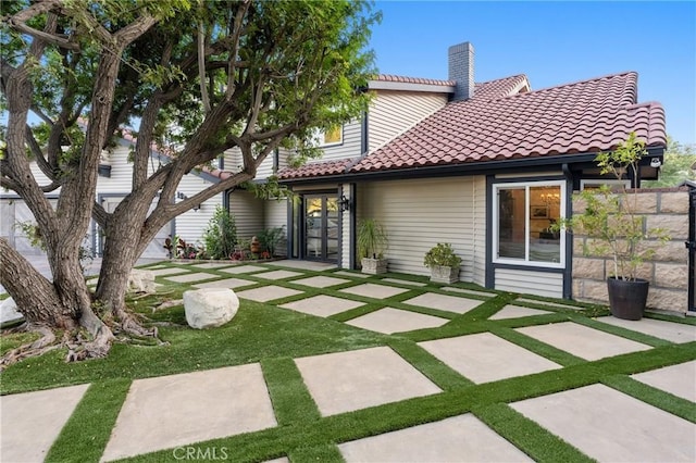 19022 Shamrock Ln, Yorba Linda, CA 92886 - back of property featuring a tiled roof, a chimney, a lawn, a patio area, and french doors