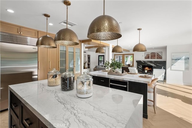 19022 Shamrock Ln, Yorba Linda, CA 92886 - kitchen featuring a kitchen island, built in refrigerator, a premium fireplace, open floor plan, and light stone countertops