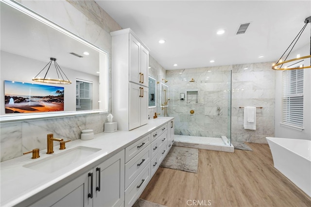 20 Becker, Ladera Ranch, CA 92694 - bathroom with wood finished floors, a freestanding bath, a marble finish shower, double vanity, and a chandelier