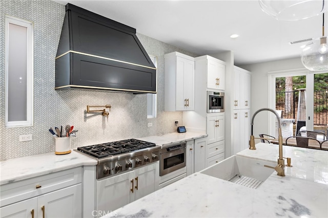 20 Becker, Ladera Ranch, CA 92694 - kitchen with stainless steel gas stovetop, custom range hood, white cabinets, and light stone counters