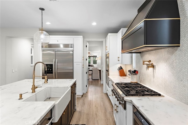 20 Becker, Ladera Ranch, CA 92694 - kitchen featuring stainless steel appliances, light wood-style floors, white cabinetry, light stone countertops, and pendant lighting