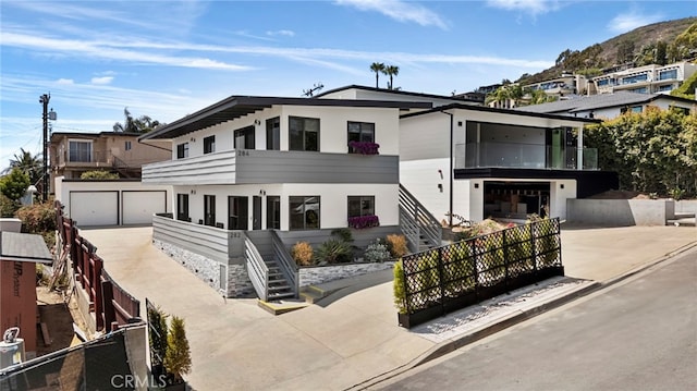 284 Chiquita St, Laguna Beach, CA 92651 - contemporary home with stairway, driveway, a balcony, an attached garage, and stucco siding