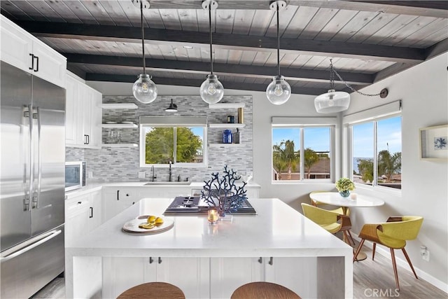 284 Chiquita St, Laguna Beach, CA 92651 - kitchen with built in appliances, a wooden ceiling with exposed beams, backsplash, light countertops, and light wood finished floors