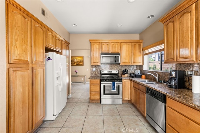 6791 Florence Pl, Rancho Cucamonga, CA 91701 - kitchen with stainless steel appliances, tasteful backsplash, light tile patterned flooring, dark stone counters, and brown cabinets