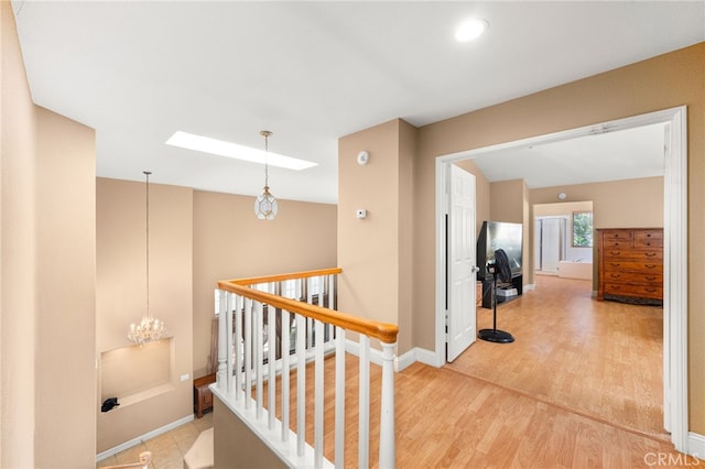 6791 Florence Pl, Rancho Cucamonga, CA 91701 - hallway with light wood-style flooring, an upstairs landing, vaulted ceiling, and a skylight