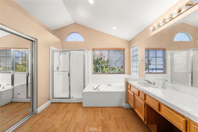 6791 Florence Pl, Rancho Cucamonga, CA 91701 - full bathroom featuring lofted ceiling, wood finished floors, vanity, a bath, and a stall shower