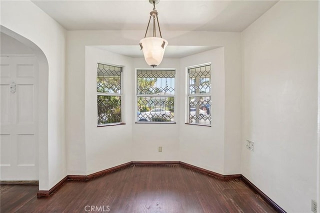 10018 San Vincente Ave, South Gate, CA 90280 - empty room featuring plenty of natural light, dark wood finished floors, and arched walkways