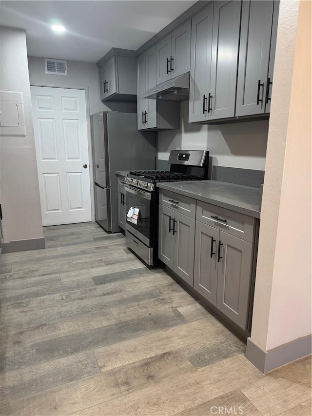 7445 Laurelgrove Ave Unit 2, North Hollywood, CA 91605 - kitchen featuring stainless steel gas range oven, under cabinet range hood, light wood-style flooring, and gray cabinetry