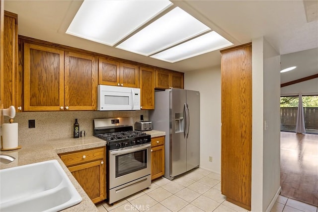 2665 Waverly Ct, Chico, CA 95973 - kitchen with stainless steel appliances, brown cabinets, tasteful backsplash, and light tile patterned floors