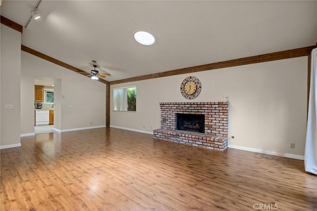2665 Waverly Ct, Chico, CA 95973 - unfurnished living room featuring wood finished floors, ceiling fan, lofted ceiling, a fireplace, and rail lighting