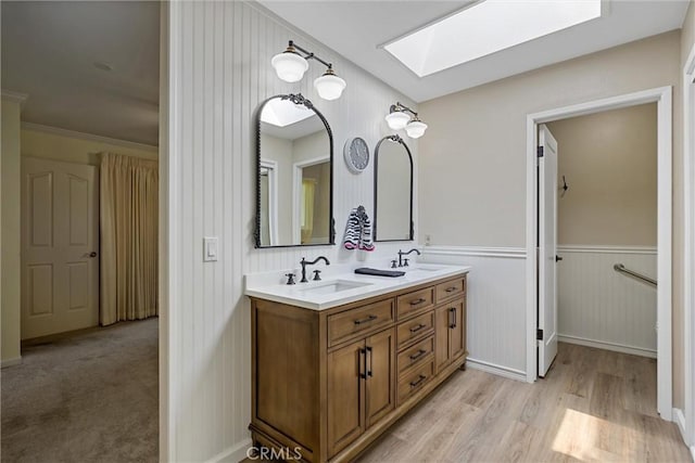 2665 Waverly Ct, Chico, CA 95973 - bathroom with a skylight, double vanity, wood finished floors, wainscoting, and a spacious closet