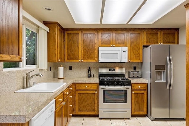 2665 Waverly Ct, Chico, CA 95973 - kitchen with appliances with stainless steel finishes, light countertops, brown cabinetry, light tile patterned flooring, and tasteful backsplash