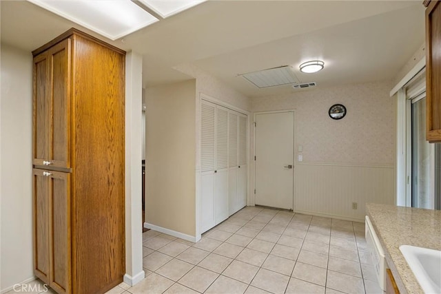 2665 Waverly Ct, Chico, CA 95973 - kitchen with light tile patterned floors, a wainscoted wall, light countertops, and brown cabinets