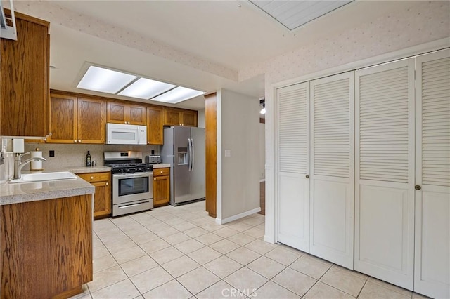 2665 Waverly Ct, Chico, CA 95973 - kitchen with appliances with stainless steel finishes, brown cabinets, light tile patterned flooring, light countertops, and backsplash
