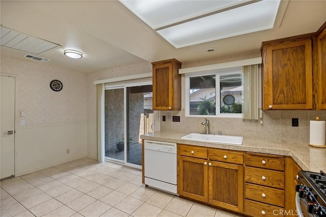 2665 Waverly Ct, Chico, CA 95973 - kitchen with white dishwasher, brown cabinets, gas range, light countertops, and wainscoting