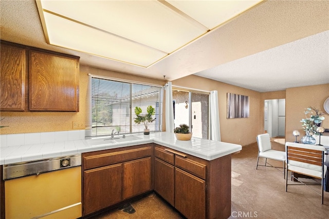 11551 Gladstone Cir, Fountain Valley, CA 92708 - kitchen with dishwashing machine, a peninsula, brown cabinetry, and tile counters
