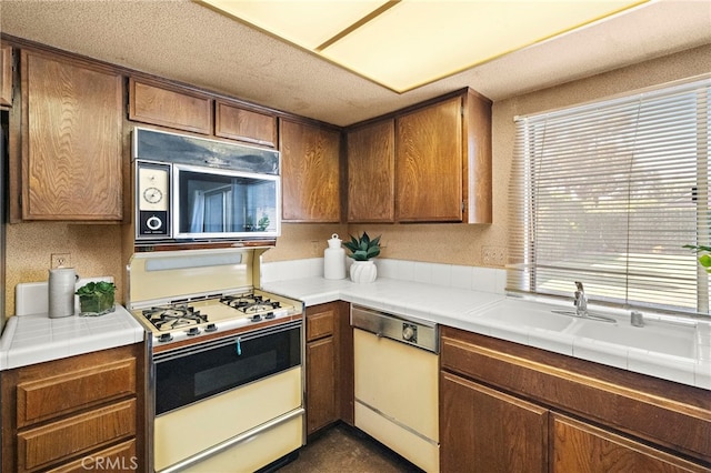 11551 Gladstone Cir, Fountain Valley, CA 92708 - kitchen featuring white appliances, brown cabinetry, and tile countertops