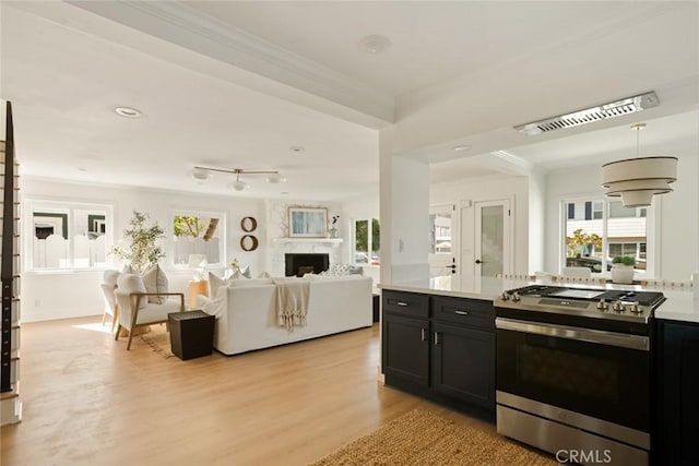 1585 Miramar Dr, Newport Beach, CA 92661 - kitchen featuring stainless steel gas range, light wood-style flooring, crown molding, a premium fireplace, and light countertops