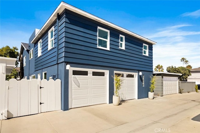 1585 Miramar Dr, Newport Beach, CA 92661 - view of side of home featuring a garage, driveway, and a gate