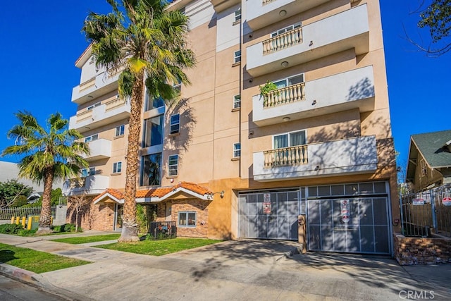 1026 S Oxford Ave Unit 206, Los Angeles, CA 90006 - view of apartment building / complex featuring concrete driveway and a garage