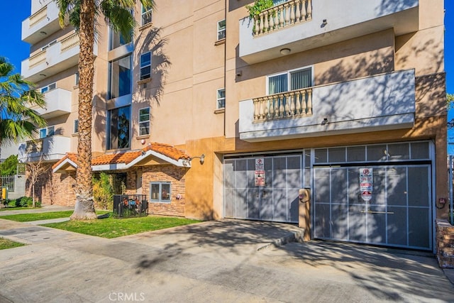1026 S Oxford Ave Unit 206, Los Angeles, CA 90006 - view of apartment building / complex featuring a garage and concrete driveway