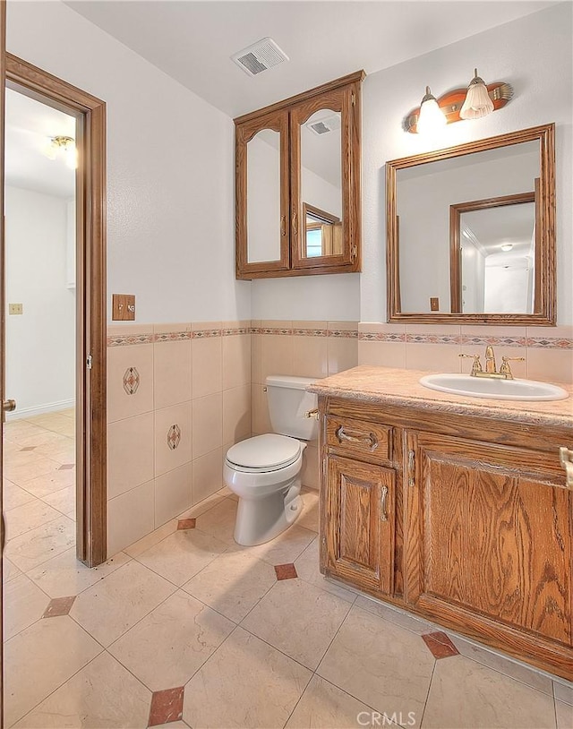 2290 Decade Ct, Riverside, CA 92506 - half bath featuring tile walls, vanity, a wainscoted wall, and tile patterned floors