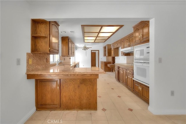 2290 Decade Ct, Riverside, CA 92506 - kitchen with white appliances, open shelves, a peninsula, light countertops, and brown cabinets