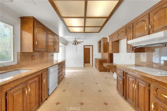 2290 Decade Ct, Riverside, CA 92506 - kitchen with dishwasher, brown cabinets, under cabinet range hood, cooktop, and a ceiling fan