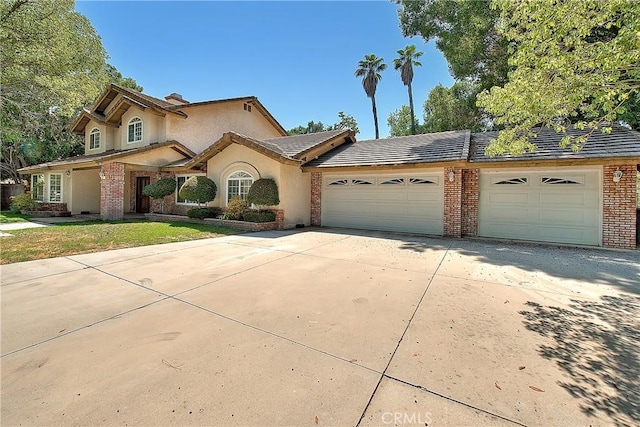2290 Decade Ct, Riverside, CA 92506 - view of front facade featuring an attached garage, brick siding, concrete driveway, and stucco siding