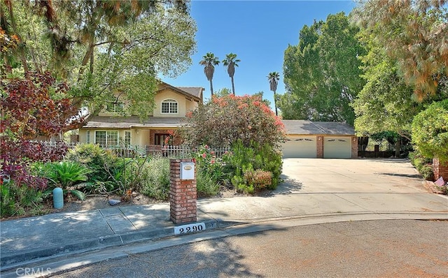 2290 Decade Ct, Riverside, CA 92506 - view of property hidden behind natural elements with driveway, stucco siding, and a garage