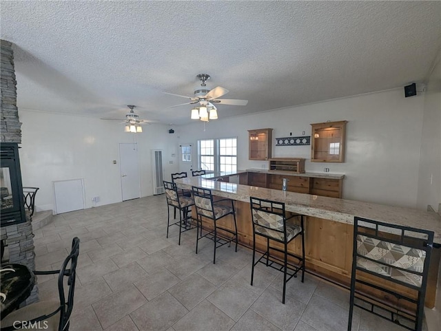 891 W Elberon Ave, San Pedro, CA 90731 - dining space featuring ceiling fan, a textured ceiling, and a stone fireplace