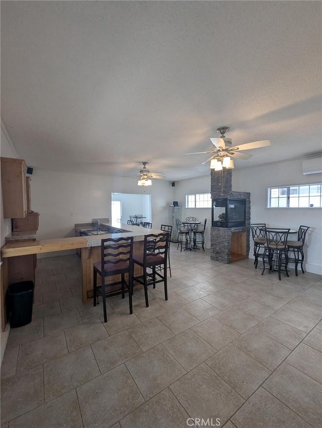 891 W Elberon Ave, San Pedro, CA 90731 - tiled dining space with a wall unit AC, plenty of natural light, a ceiling fan, and a textured ceiling