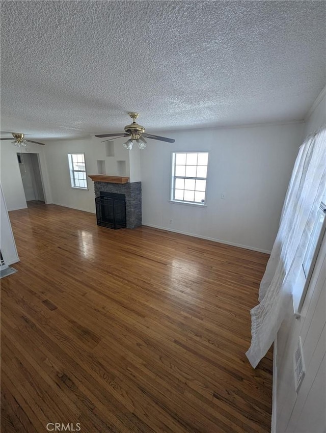 891 W Elberon Ave, San Pedro, CA 90731 - unfurnished living room featuring ceiling fan, a textured ceiling, healthy amount of natural light, a fireplace, and wood finished floors