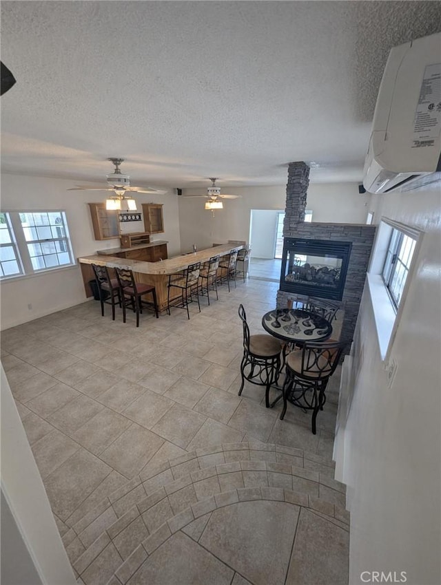 891 W Elberon Ave, San Pedro, CA 90731 - dining space with a textured ceiling, ceiling fan, a multi sided fireplace, and a wall mounted AC