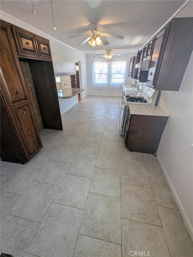 891 W Elberon Ave, San Pedro, CA 90731 - kitchen featuring gas stove, a textured ceiling, light countertops, ceiling fan, and light tile patterned flooring