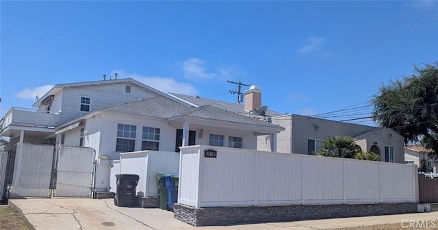 891 W Elberon Ave, San Pedro, CA 90731 - view of side of home featuring a gate, roof with shingles, and a chimney