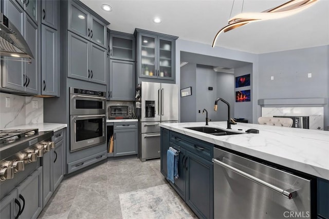 185 Alabaster Loop, Perris, CA 92570 - kitchen featuring appliances with stainless steel finishes, extractor fan, light stone counters, backsplash, and glass insert cabinets