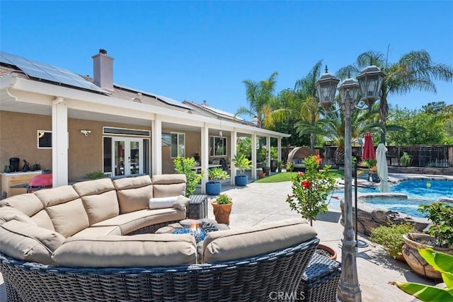 185 Alabaster Loop, Perris, CA 92570 - fenced backyard featuring french doors, an outdoor living space with a fire pit, a patio area, and a pool with connected hot tub