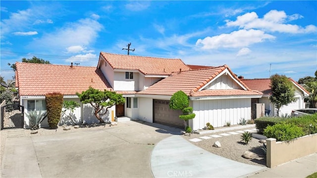 17698 Locust St, Fountain Valley, CA 92708 - view of front facade with a tile roof, concrete driveway, an attached garage, board and batten siding, and a gate