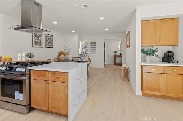 17698 Locust St, Fountain Valley, CA 92708 - kitchen featuring stainless steel gas range oven, island exhaust hood, light wood-style floors, recessed lighting, and light stone countertops