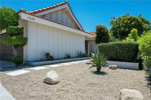 17698 Locust St, Fountain Valley, CA 92708 - view of front facade featuring a tile roof, board and batten siding, and a garage