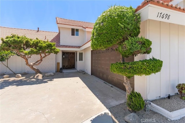 17698 Locust St, Fountain Valley, CA 92708 - property entrance with a tile roof, stucco siding, and a garage