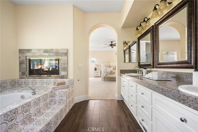 2 Via Barcaza, Coto De Caza, CA 92679 - ensuite bathroom featuring double vanity, a garden tub, wood finished floors, ceiling fan, and a tiled fireplace
