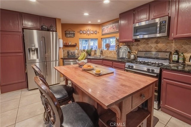24000 Wheatfield Cir, Wildomar, CA 92595 - kitchen with stainless steel appliances, butcher block countertops, light tile patterned flooring, backsplash, and recessed lighting