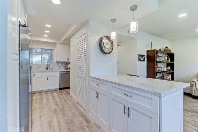 3365 Punta Alta Unit 2F, Laguna Woods, CA 92637 - kitchen with appliances with stainless steel finishes, light wood finished floors, white cabinetry, light stone counters, and recessed lighting