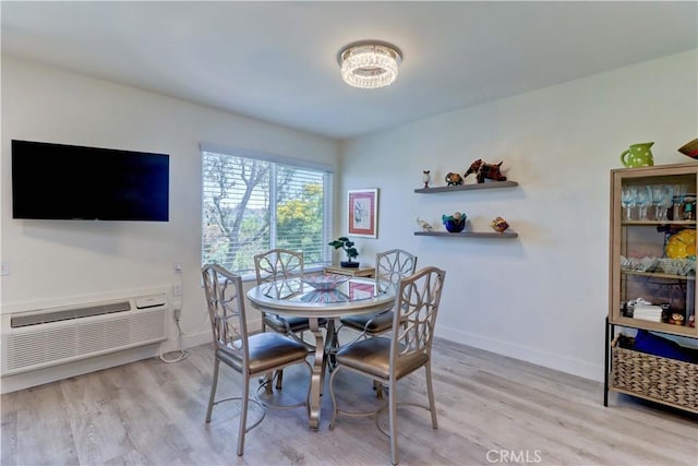 3365 Punta Alta Unit 2F, Laguna Woods, CA 92637 - dining area with light wood-style floors, a wall unit AC, and a chandelier